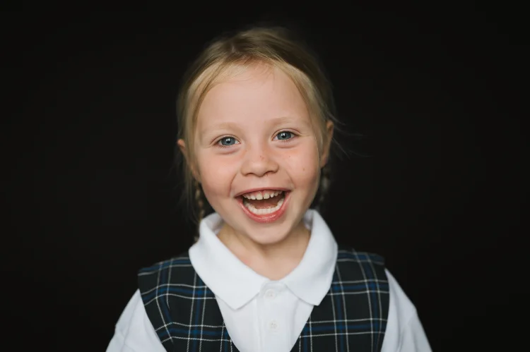 Smiling Early Years pupil in uniform