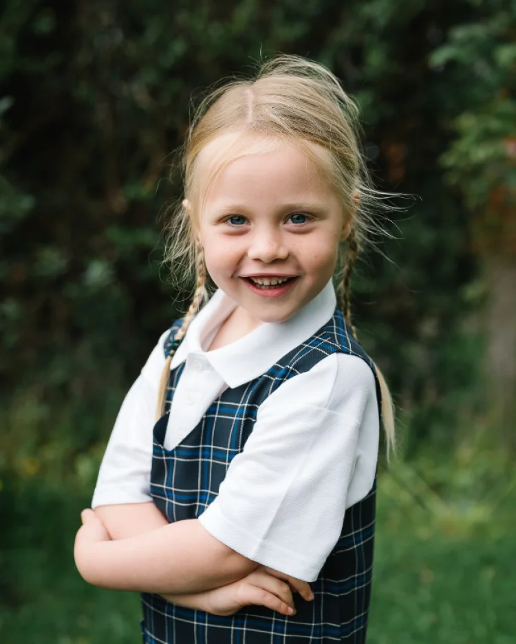 A smiling child in a school uniform