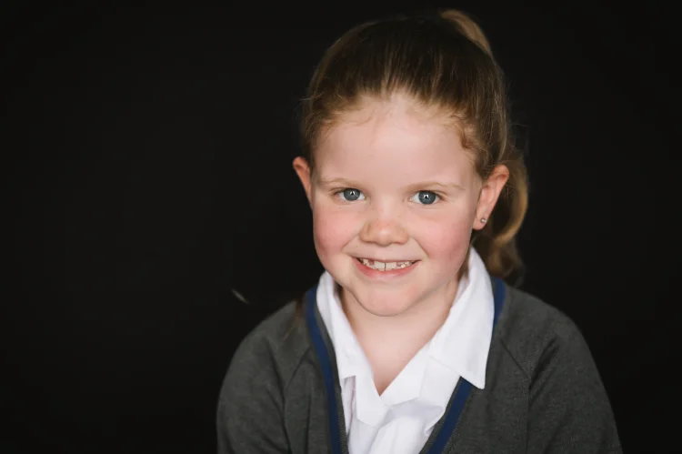 A smiling student in a school jumper